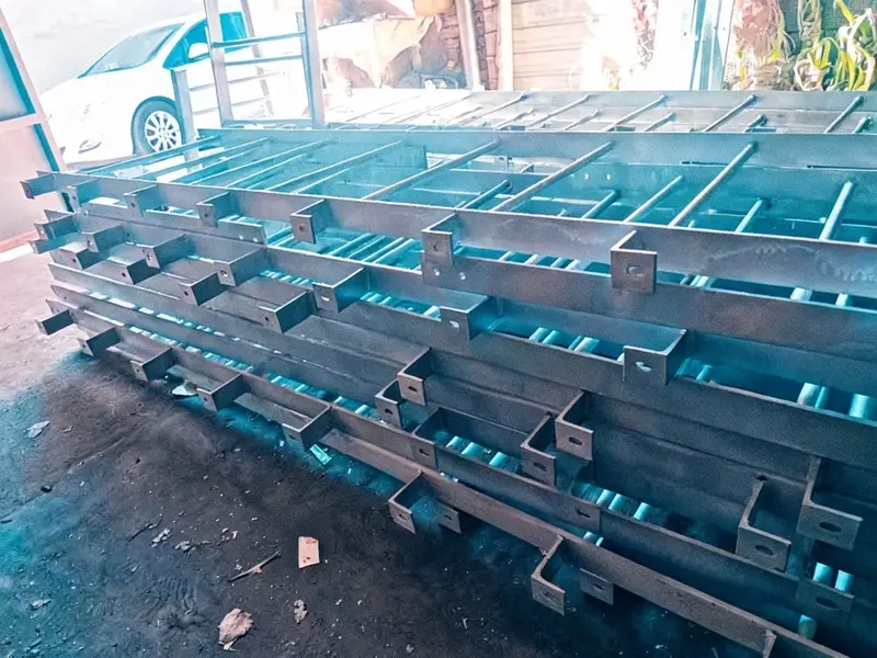 Échelle à crinoline à arceaux ronds sur dalle béton, mur bleu en arrière-plan