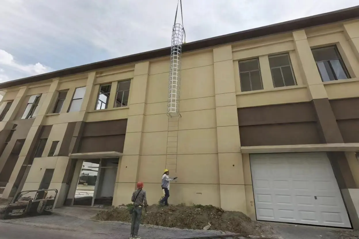 Échelle à crinoline levée vers la façade lors du montage